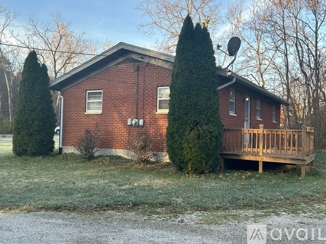 A red brick house with a satellite dish on the roof.