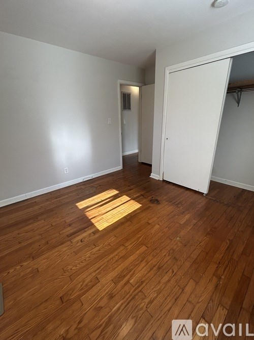 A room with wooden flooring and a white door.