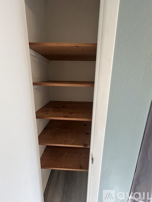 Empty wooden shelves in a white closet.