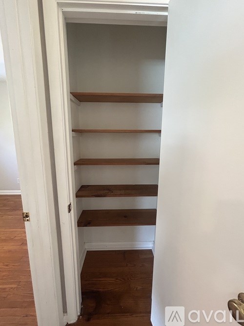 A white door with a shelf underneath it.