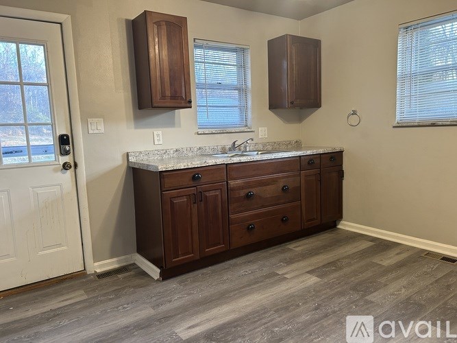 A kitchen with brown cabinets and a marble countertop.