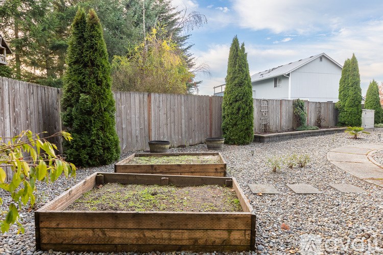 A backyard with a wooden fence and a raised garden bed.