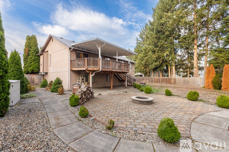A house with a patio and a fire pit in the front yard.