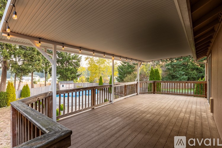 A wooden deck with a pool in the background.