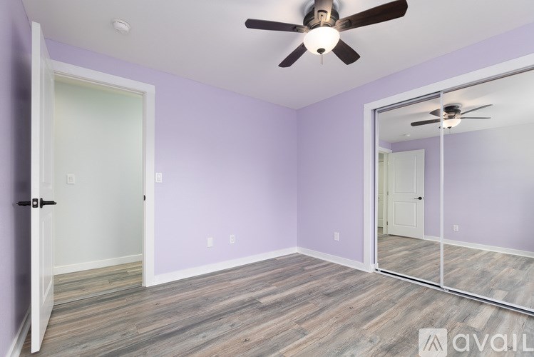 A room with a ceiling fan and mirrored door.