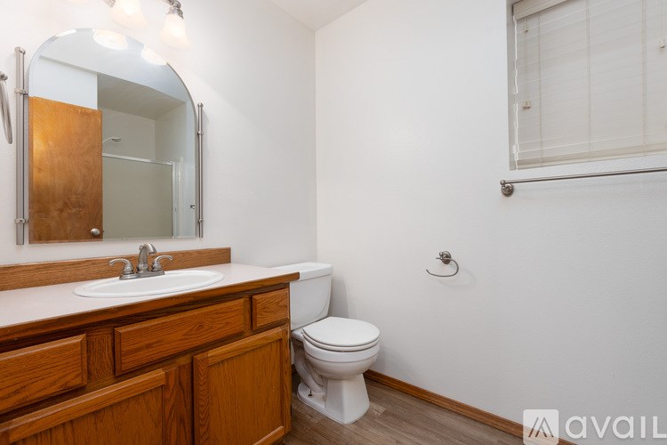 A bathroom with a wooden vanity and a white toilet.