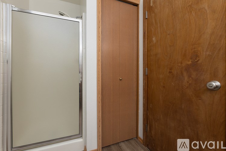 A wooden door is next to a glass door.