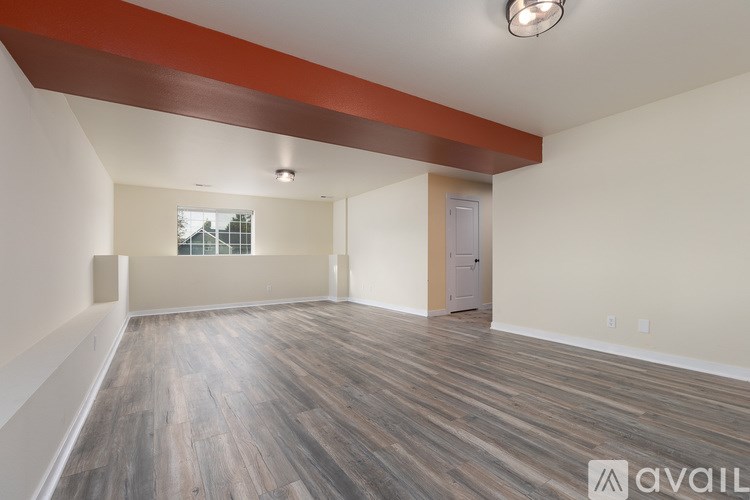 A room with wooden flooring and a window.