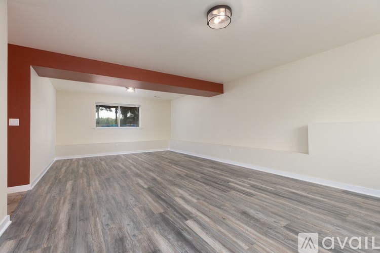A room with wooden flooring and a window.