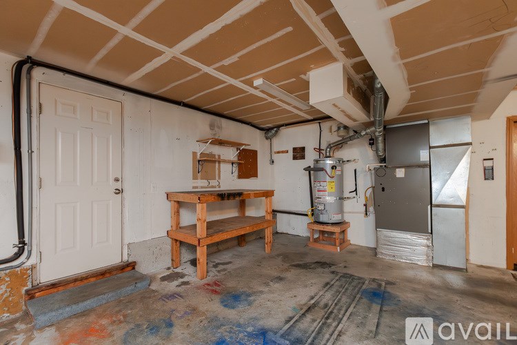 A room with a wooden table and chairs, a refrigerator, and a water heater.