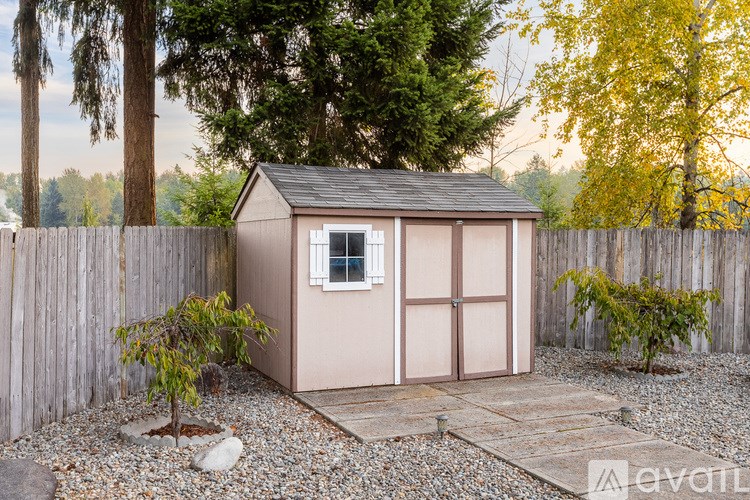 A small house with a brown roof and a brown fence.