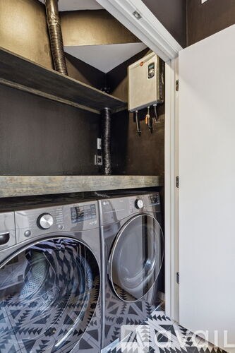 A washing machine is in a small laundry room.