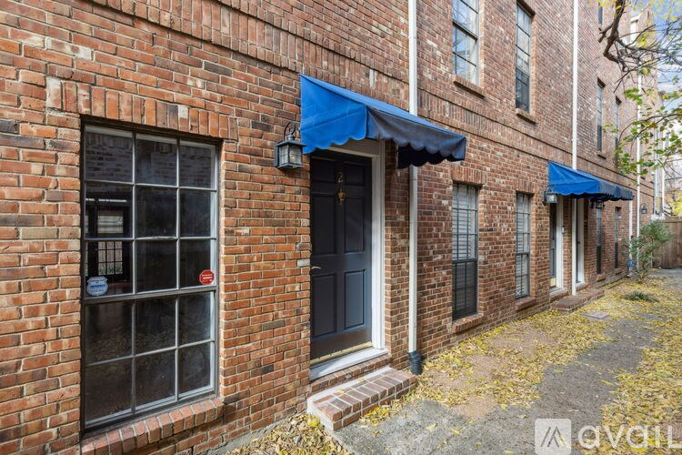 A brick building with a blue awning and a sign that says "available".
