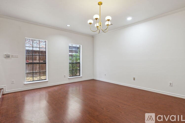 A room with a wooden floor and a chandelier.