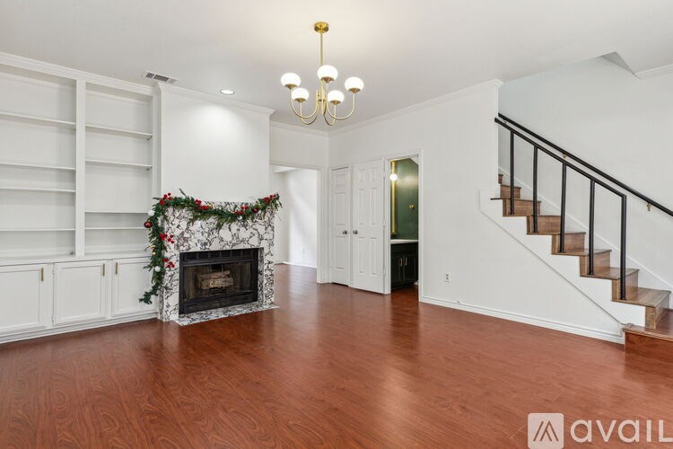 A living room with a fireplace and a staircase.