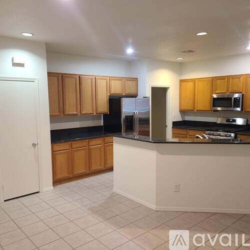 A kitchen with wooden cabinets and black countertops.