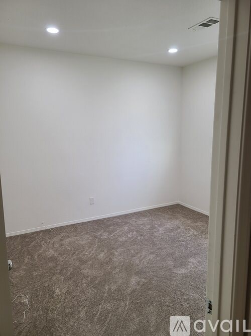 A room with carpeted floor and white walls.