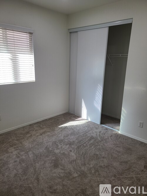 A room with a carpeted floor and a door leading to another room.