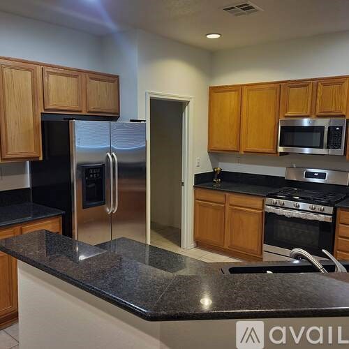 A kitchen with wooden cabinets and a granite countertop.