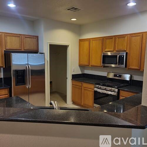 A kitchen with wooden cabinets and a black countertop.