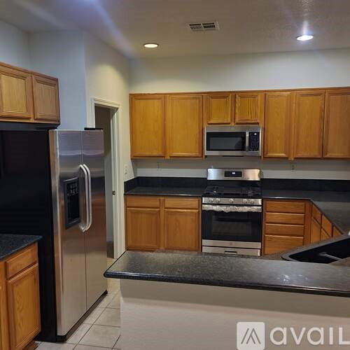 A kitchen with wooden cabinets and a black countertop.