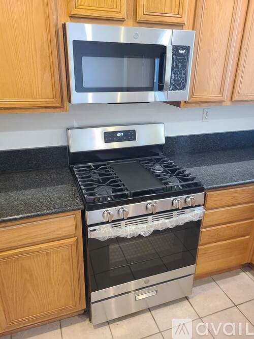 A modern kitchen with a stainless steel stove and microwave above it.