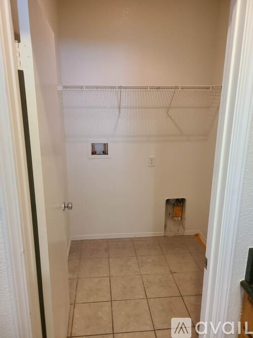 A small, empty room with a tiled floor and a white wall.