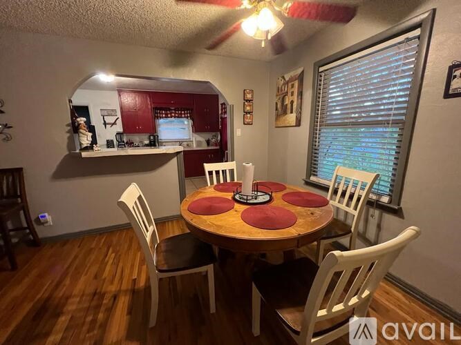 A dining room with a round table and chairs.
