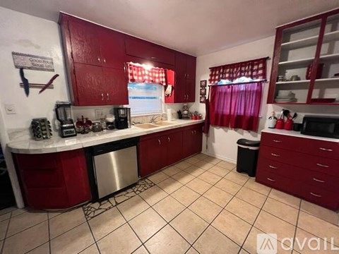 A kitchen with red cabinets and a white countertop.