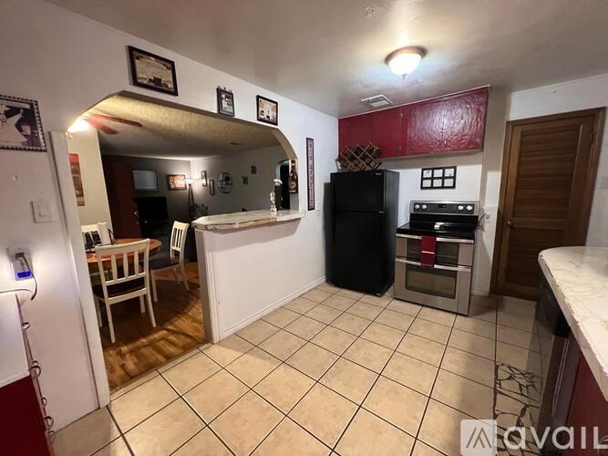 A kitchen with a black refrigerator and a white counter.