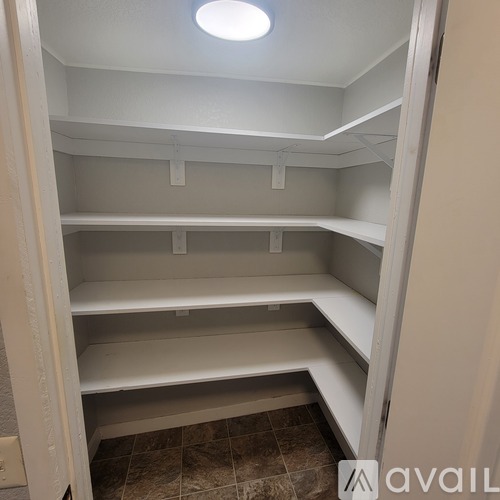 Empty white shelves in a room with a tiled floor.