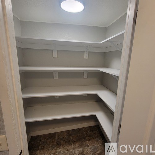 Empty white shelves in a room with a tiled floor.
