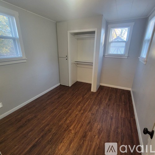 A room with wooden flooring and white walls.