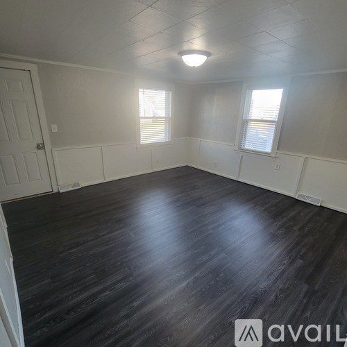 A room with wooden flooring and white walls.