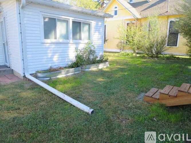 A white house with a long white pipe in the yard.