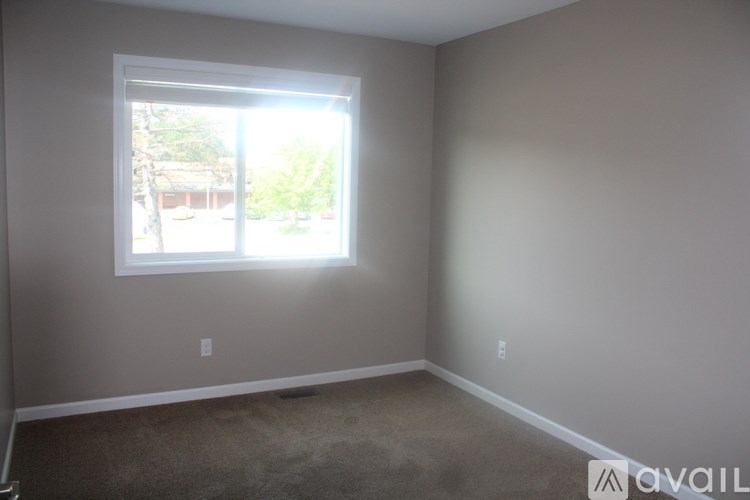 A room with a window and carpeted floor.