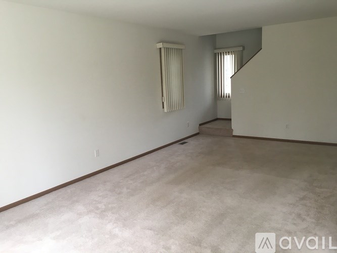 Empty room with a staircase on the right side.