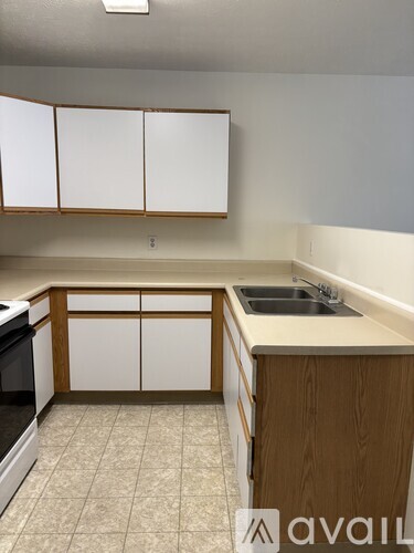 A kitchen with white cabinets and a wooden island.