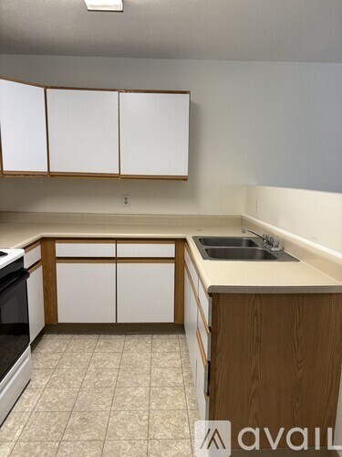 A kitchen with white cabinets and a wooden island.