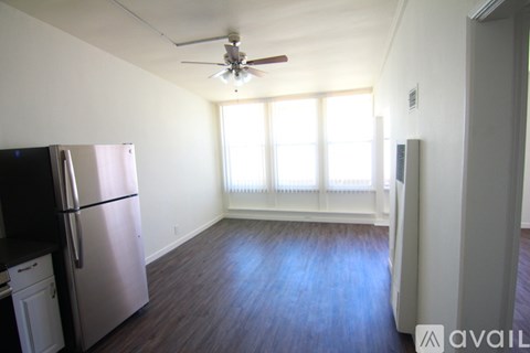 A kitchen with a black fridge and a fan on the ceiling.