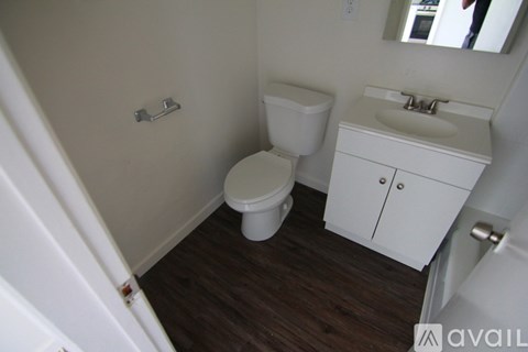 A white toilet and sink in a small bathroom.