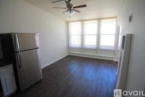 A kitchen with a refrigerator and a fan.