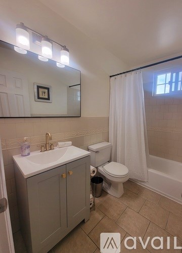 A bathroom with a sink, toilet, and a mirror.