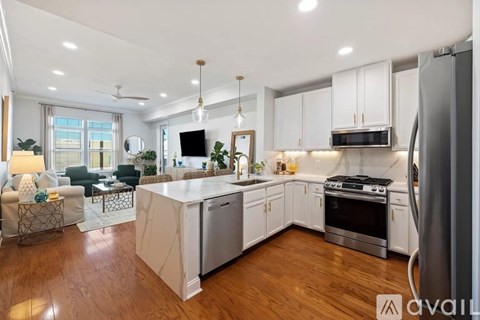 A modern kitchen with white cabinets and stainless steel appliances.