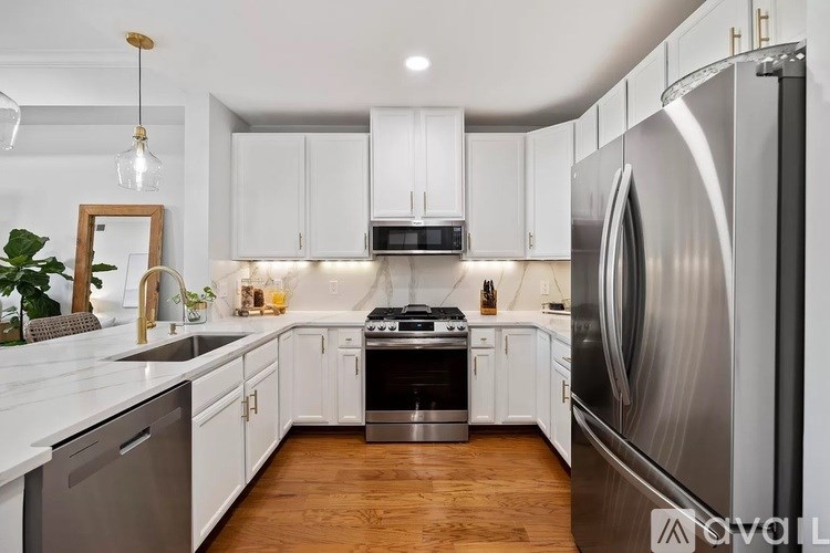A modern kitchen with white cabinets and stainless steel appliances.