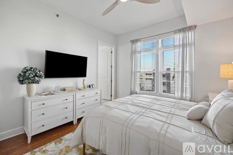 A bedroom with a bed, dresser, and tv.