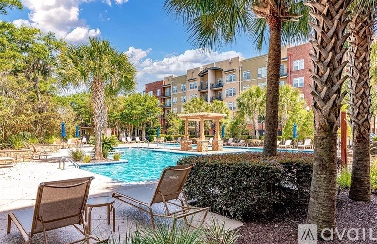 A pool surrounded by palm trees and chairs.