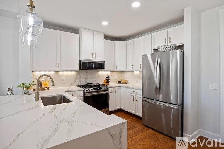 A kitchen with a marble countertop and stainless steel appliances.