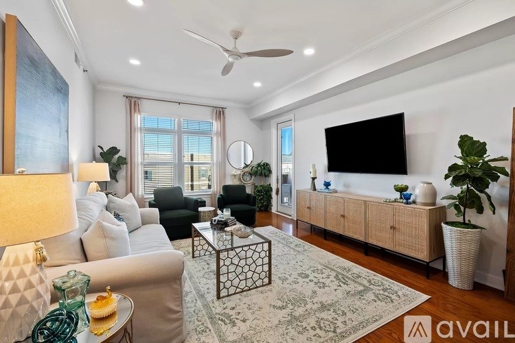 A living room with a couch, a coffee table, a TV, and a plant.