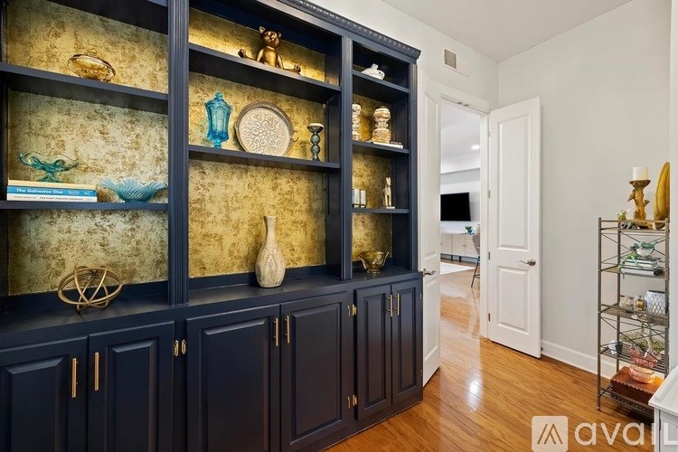 A room with a cabinet and a shelf with various objects on it.